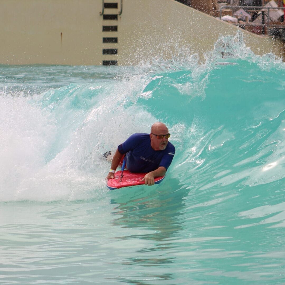 Man bodyboarding inside a turquoise wave